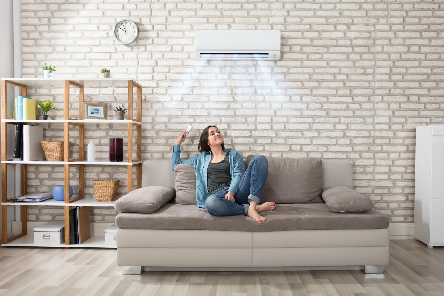 Woman on sofa with air con above